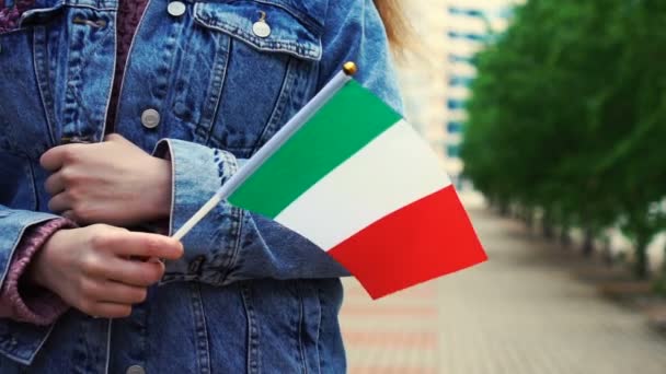 Lambat gerak: dikenali wanita memegang bendera Italia. Gadis berjalan menyusuri jalan dengan bendera nasional Italia — Stok Video