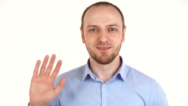 Hombre europeo guapo sonriendo a la cámara y agitando su mano . — Vídeo de stock