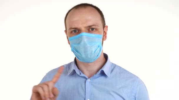 Hombre europeo guapo con máscara protectora diciendo no agitando su dedo . — Vídeo de stock