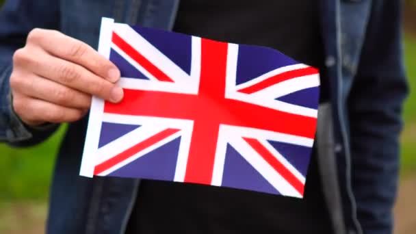 在户外举着英国国旗的人。独立日或国定假日的概念 — 图库视频影像