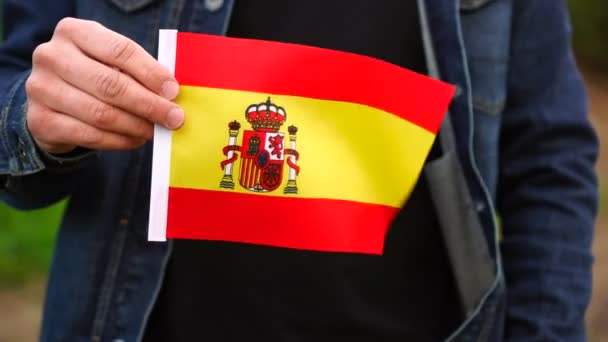 Hombre sosteniendo bandera de España al aire libre. Día de la Independencia, o conceptos nacionales de fiestas — Vídeo de stock