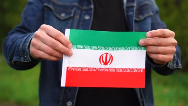 Hombre sosteniendo bandera iraní al aire libre. Día de la Independencia, o conceptos nacionales de fiestas — Vídeos de Stock