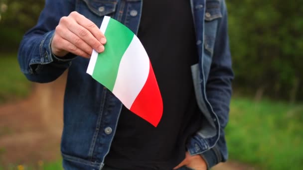 Hombre sosteniendo bandera italiana al aire libre. Día de la Independencia, o conceptos nacionales de fiestas — Vídeo de stock
