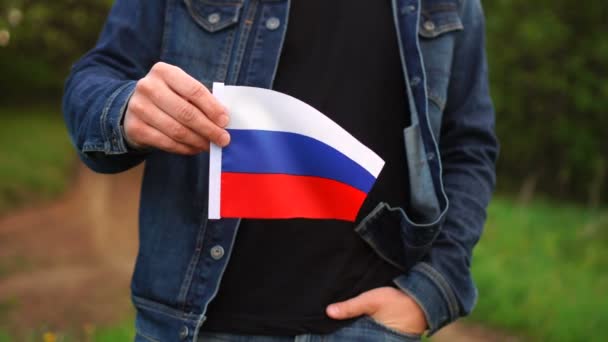 Человек, держащий российский флаг на улице. День независимости или национальные праздники — стоковое видео
