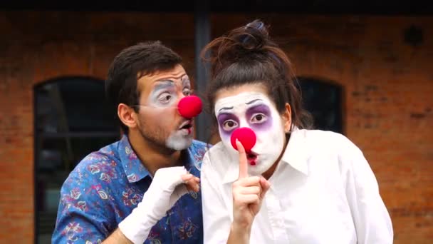 Vertel het aan niemand. Twee clowns glimlachend en met de vinger op de lippen stille gebaren makend, stil vragend om geheim te blijven — Stockvideo