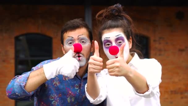 Два смешных клоуна держат большие пальцы — стоковое видео