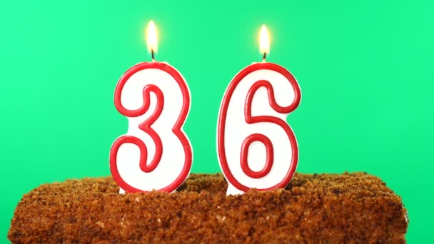 36号的蛋糕点燃了蜡烛。铬键。绿色屏风。被隔离了 — 图库视频影像