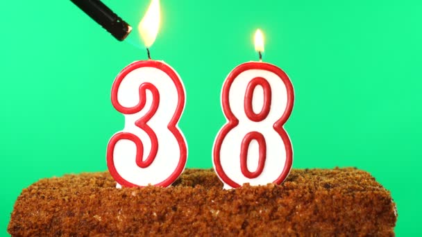 38号的蛋糕点燃了蜡烛。铬键。绿色屏风。被隔离了 — 图库视频影像