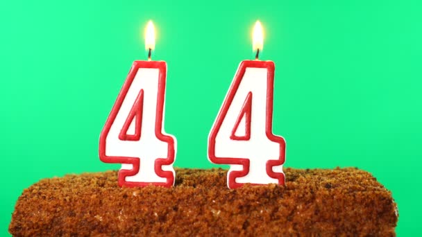 44号的蛋糕点燃了蜡烛。铬键。绿色屏风。被隔离了 — 图库视频影像