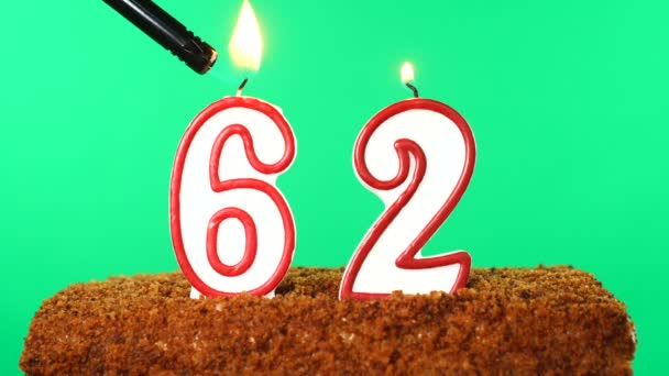 Ciasto z cyfrą 62 zapaloną świecą. Klucz chromowy. Zielony ekran. Izolacja — Wideo stockowe