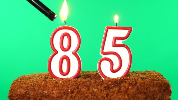 85号的蛋糕点燃了蜡烛。铬键。绿色屏风。被隔离了 — 图库视频影像