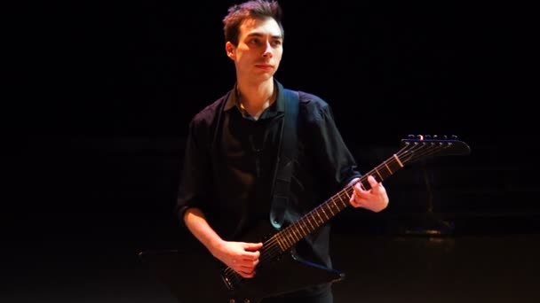 Knappe jonge gitarist die op het podium speelt. Professionele prestaties — Stockvideo