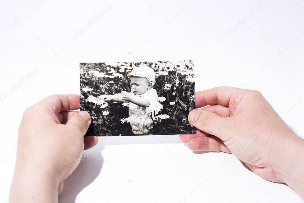 Old paper photo in mans hands. Abstract photo of childhood.