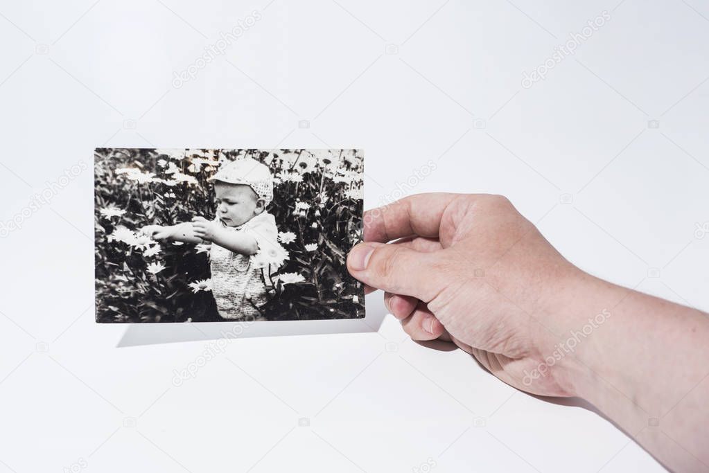 Old paper photo in mans hands. Abstract photo of childhood.