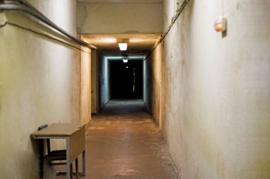 Uzun karanlık yeraltı tüneli binanın içinde. Bir tünelin sonunda ışık. Soyut fotoğraf.