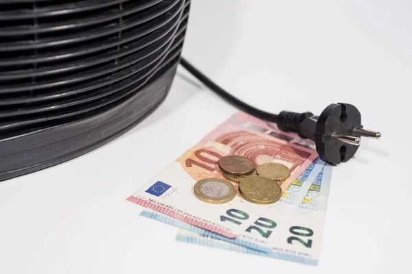 Money for heating bills with black heater on white background. Autumn season.