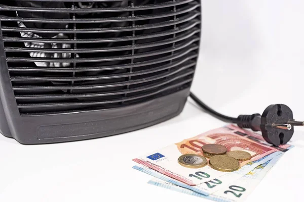 Money for heating bills with black heater on white background. Autumn season.