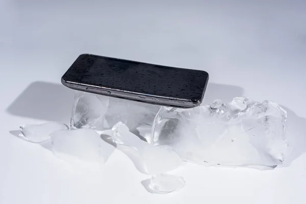 氷でフリーズの黒いスマート フォン 抽象オブジェクトの写真 — ストック写真