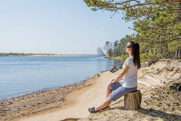 Portret van lachende jonge vrouw die aan zee kust — Stockfoto