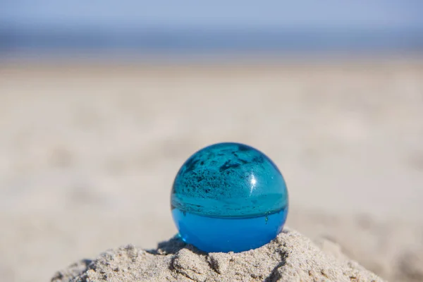 Glass sphere at the beach. Sunny summer day.