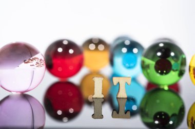 Şeffaf cam toplar ve ahşap harflerle soyut kompozisyon.