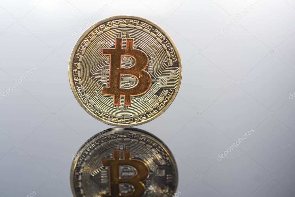 Golden Bitcoin on glass table. Abstract photo of virtual cryptocurrency.