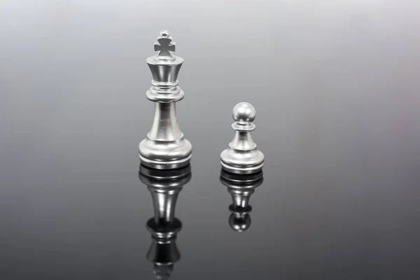 Abstract composition of chess figures. Isolated chess on black mirror.