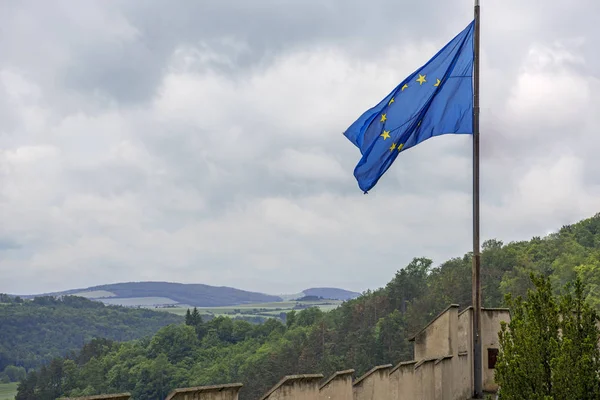 Az Európai Unió, az EU zászlaja, a háttérben futó drámai égről. — Stock Fotó