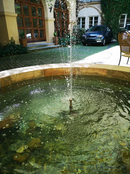 European furniture and fountain settled at a public park on a hot summer day.