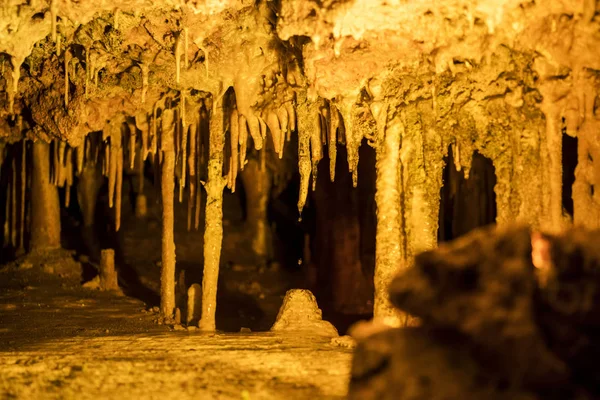 Cave dark interior with light, stalactites and stalagmites — Stock Photo, Image