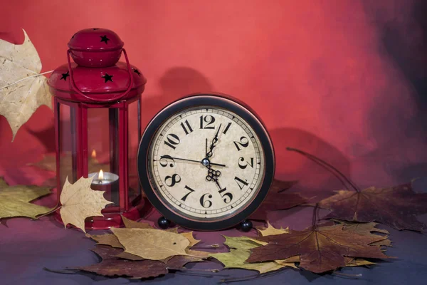가 잎에 빈티지 블랙 알람 시계입니다. 시간 변경 추상 사진입니다. 일광 절약 시간. — 스톡 사진