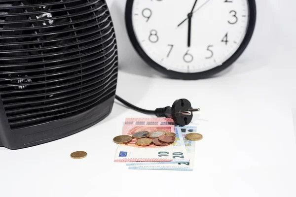 Money for heating bills with black heater on white background. Autumn season.