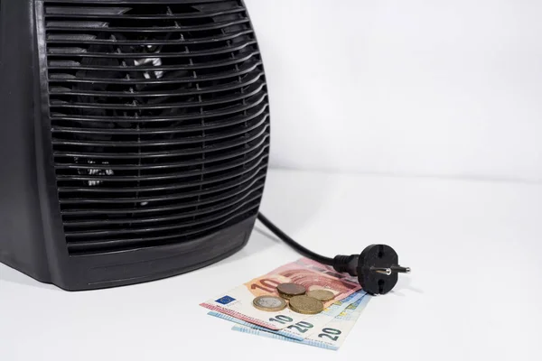 Money for heating bills with black heater on white background. Autumn season.