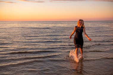 Güzel genç kadın gün batımında dinleniyor.
