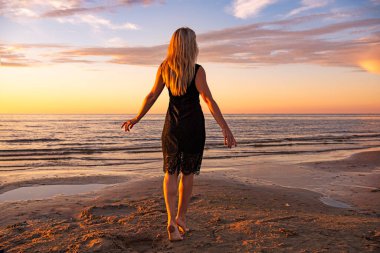 Güzel genç kadın gün batımında dinleniyor.