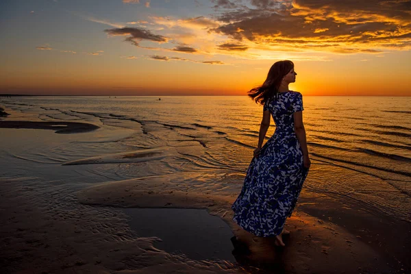 Güzel genç kadın gün batımında dinleniyor.