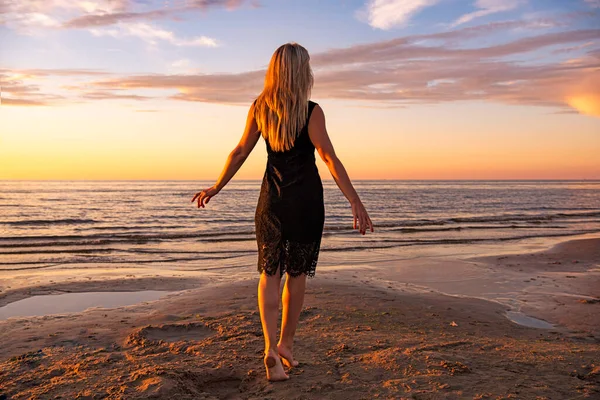 Güzel genç kadın gün batımında dinleniyor.