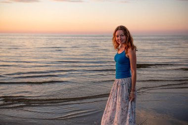 Güzel genç kadın gün batımında dinleniyor.