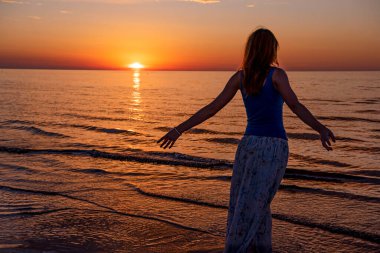 Güzel genç kadın gün batımında dinleniyor.