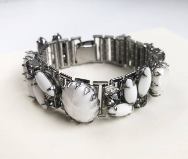 Beyaz arka planda gümüş bilezik. Doğal taştan yapılmış bilezik..