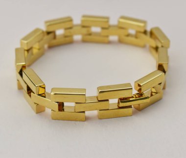 Beyaz arka planda altın külçelerden yapılmış bilezik.