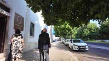 Lisbon summer POV photo with tiled buildings cobblestone street and travel vibes