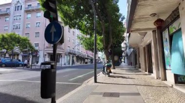 Walking Lisbon streets POV summer sun shining on historic architecture European vacation urban vibes