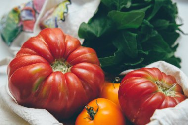 Yeniden kullanılabilir çevre dostu bez torbaları sarı domates ve ıspanak ile. Yerel pazar sebze. Çiftçilerin ürünleri. Filtre uygulanan görüntü işleme