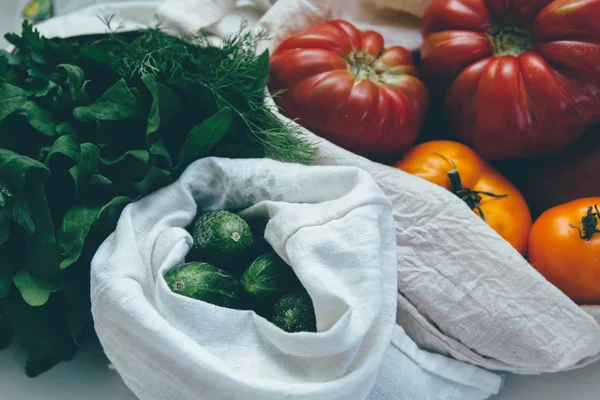 Çevre dostu bez torbaları salatalık, domates ve yeşillik ile. Yerel pazar sebze yeniden kullanılabilir çanta içinde 