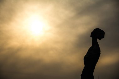 Ay çerçevede bir kadın heykelinin siluetleri