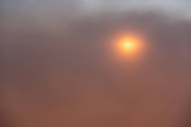 Puslu gökyüzünde turuncu günbatımı