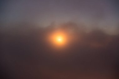 Puslu gökyüzünde turuncu günbatımı