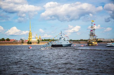 Şehir limanında binaların arka planına karşı şenlikli kurdelelerle süslenmiş gri savaş gemisi