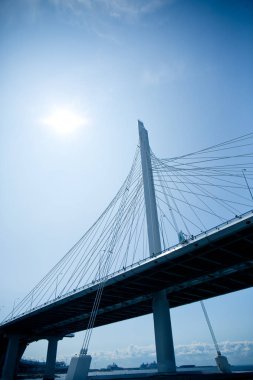 Gri yüksek hızlı trafik için mavi gökyüzüne karşı boğazdan geçen karayolu köprüsü